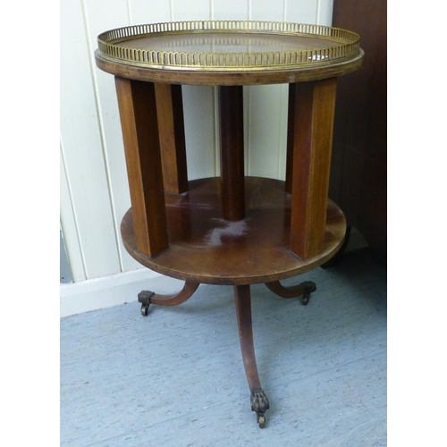 268 - An Edwardian mahogany revolving bookcase with a brass gallery, raised on a tripod base&nbsp; 26