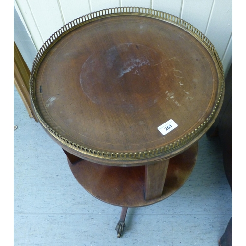 268 - An Edwardian mahogany revolving bookcase with a brass gallery, raised on a tripod base&nbsp; 26