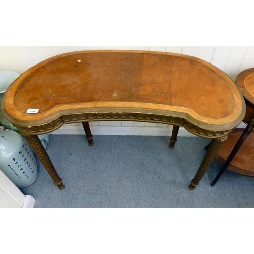 294 - A modern gilt overpainted kidney shaped table, the showwood top raised on spiral, fluted legs and bu... 