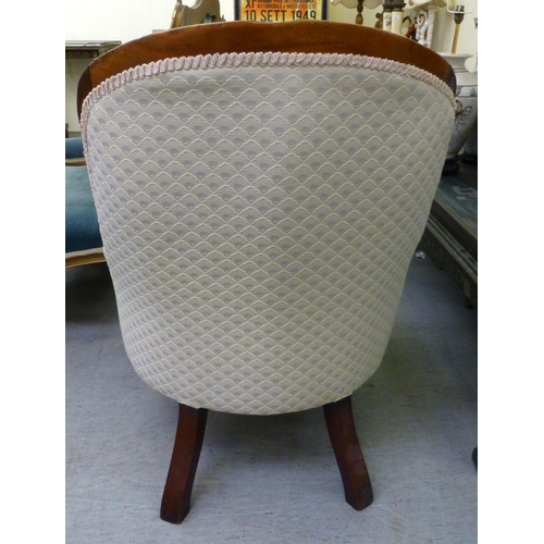 300 - A late 19thC mahogany framed salon chair with a cream fabric upholstered back and seat, raised on ca... 