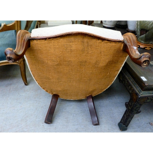 300 - A late 19thC mahogany framed salon chair with a cream fabric upholstered back and seat, raised on ca... 