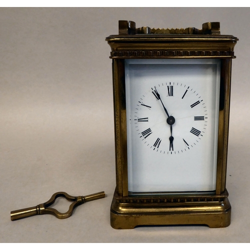 33 - A lacquered brass travel timepiece with bevelled glass panels; the movement faced by an enamelled Ro... 