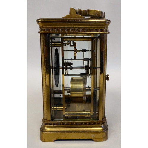 33 - A lacquered brass travel timepiece with bevelled glass panels; the movement faced by an enamelled Ro... 