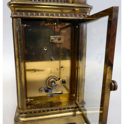 33 - A lacquered brass travel timepiece with bevelled glass panels; the movement faced by an enamelled Ro... 
