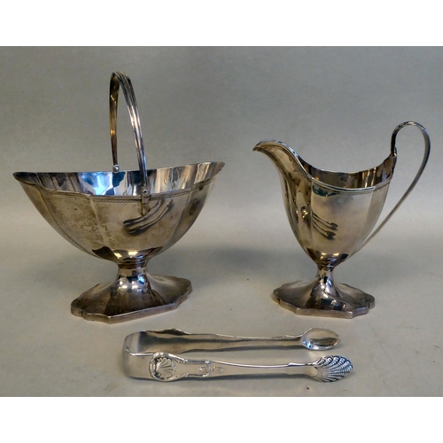 43 - A Georgian silver pedestal sugar basket of oval outline with a swing handle and a matching cream jug... 