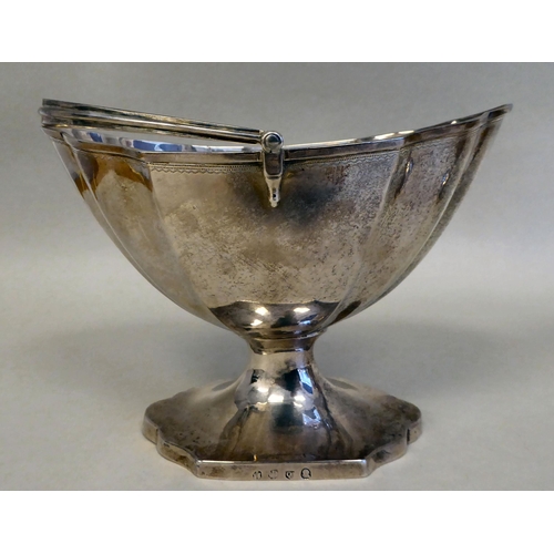 43 - A Georgian silver pedestal sugar basket of oval outline with a swing handle and a matching cream jug... 