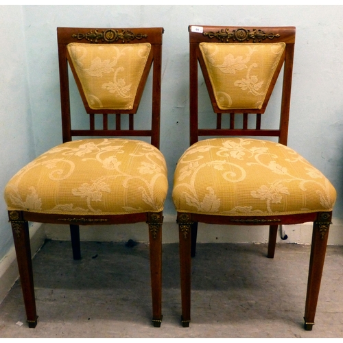 60 - A pair of late 19thC walnut framed, ormolu mounted bedroom chairs, each with an upholstered back and... 