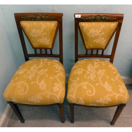 60 - A pair of late 19thC walnut framed, ormolu mounted bedroom chairs, each with an upholstered back and... 