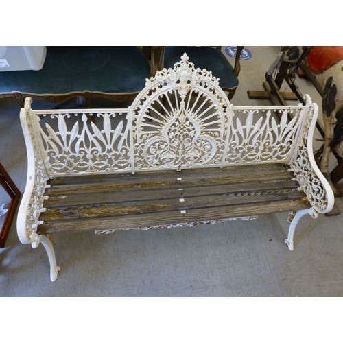 250 - A modern cast iron three person garden bench with a slatted wooden seat  62