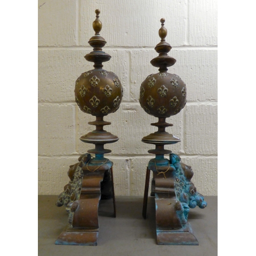 152 - A pair of late 19th/early 20thC cast bronzed fire dogs, fashioned vases with fancy rims, on a steppe... 