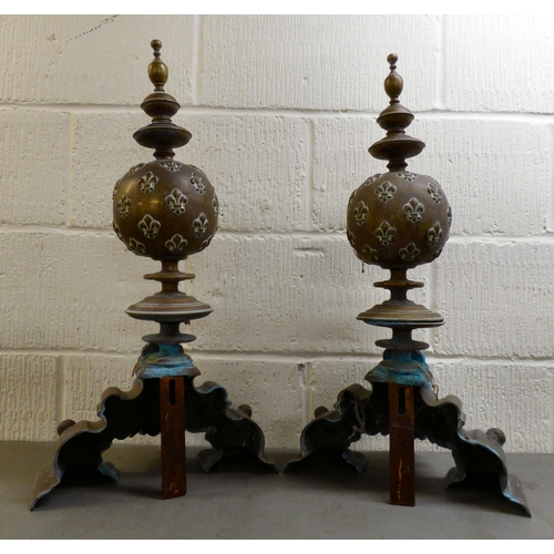 152 - A pair of late 19th/early 20thC cast bronzed fire dogs, fashioned vases with fancy rims, on a steppe... 