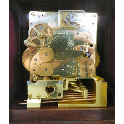 32 - A modern reproduction of a Georgian mahogany mantel timepiece by Knight & Gibbins of London; the... 