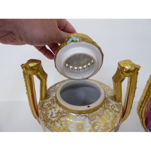 17 - A pair of Augustus Rex porcelain pedestal vases and covers, painted and hand finished, decorated wit... 