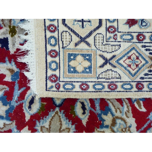 31 - A Persian rug, decorated with a central medallion, bordered by mainly floral designs, on a multi-col... 