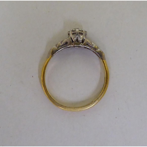 53 - A Bravington's yellow metal ring, set with a central claw set diamond, flanked by diamond chips  sta... 