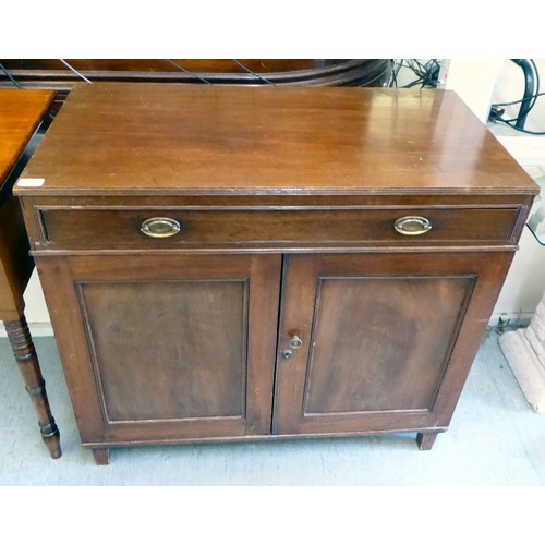 27 - An early/mid 19thC mahogany side cabinet with a frieze drawer, over a pair of panelled doors, raised... 