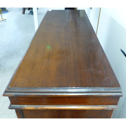 3 - An early 20thC mahogany two door cabinet, enclosing two shelves, over three in-line drawers, raised ... 