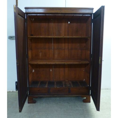 3 - An early 20thC mahogany two door cabinet, enclosing two shelves, over three in-line drawers, raised ... 