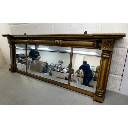 6 - A late 19thC gilt painted, inverted breakfront mirror, the three section plate set between pillar or... 