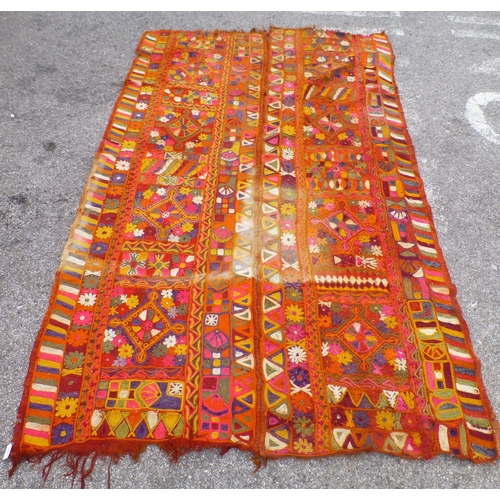 An Iraqi rug, decorated with geometric motifs, on a multi-coloured ...
