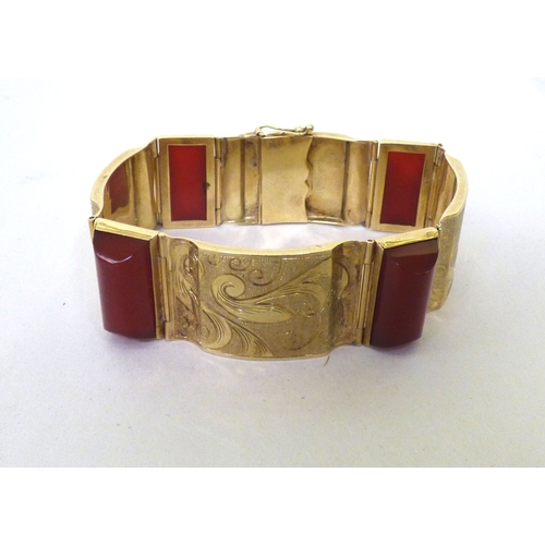 111 - A yellow metal and red tablet set, hinged bracelet&nbsp; (approx. 26grms)&nbsp;
