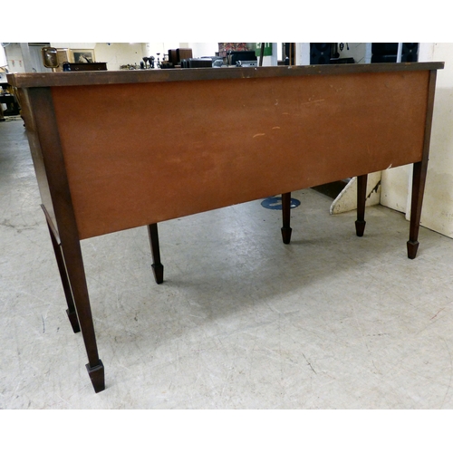 177 - A mid 20thC mahogany finished serpentine front sideboard, comprising an arrangement of drawers and c... 