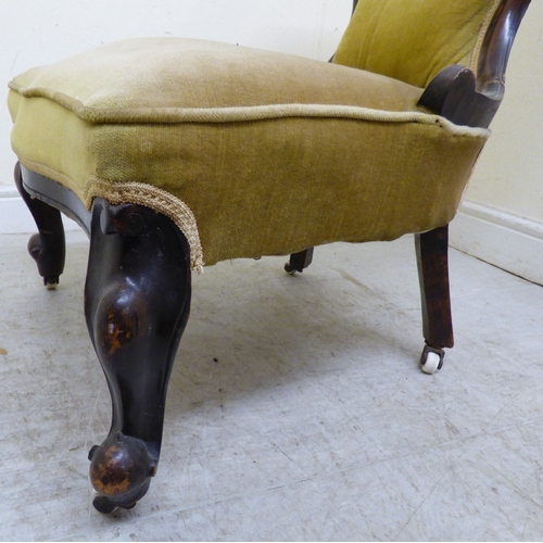 180 - A late 19thC walnut framed salon chair with a button upholstered back and seat, raised on cabriole l... 