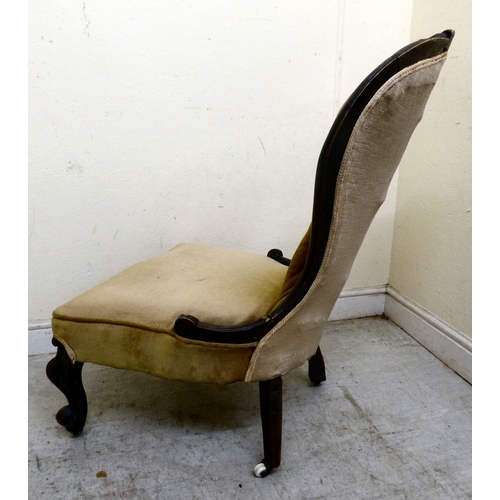 180 - A late 19thC walnut framed salon chair with a button upholstered back and seat, raised on cabriole l... 