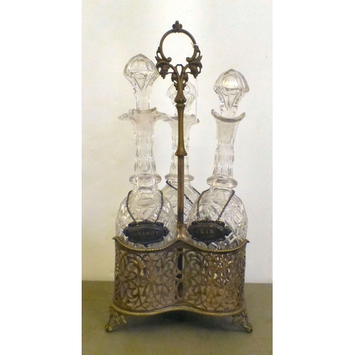 84 - An early 20thC silver plated decanter tantalus with three decanters and stoppers  bearing individual... 