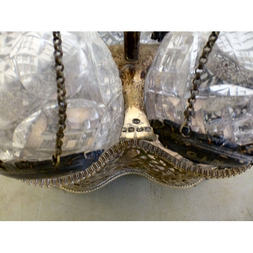 84 - An early 20thC silver plated decanter tantalus with three decanters and stoppers  bearing individual... 