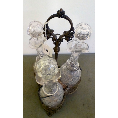 84 - An early 20thC silver plated decanter tantalus with three decanters and stoppers  bearing individual... 