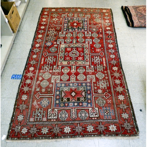 85 - A Kurdish rug, decorated with geometric and stylised designs, on a red ground&nbsp; 52