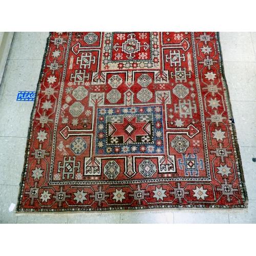 85 - A Kurdish rug, decorated with geometric and stylised designs, on a red ground&nbsp; 52