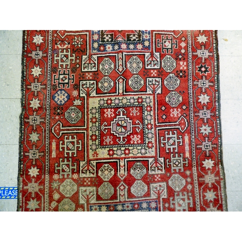 85 - A Kurdish rug, decorated with geometric and stylised designs, on a red ground&nbsp; 52