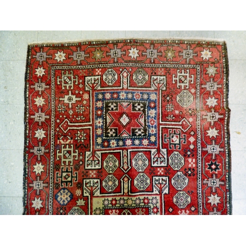 85 - A Kurdish rug, decorated with geometric and stylised designs, on a red ground&nbsp; 52