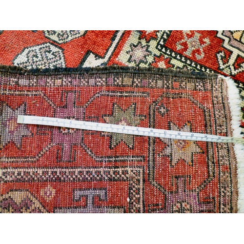 85 - A Kurdish rug, decorated with geometric and stylised designs, on a red ground&nbsp; 52
