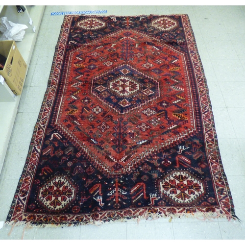 86 - A Persian rug, decorated with repeating stylised designs, on a multi-coloured ground&nbsp; 62