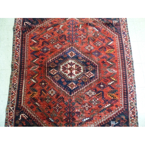 86 - A Persian rug, decorated with repeating stylised designs, on a multi-coloured ground&nbsp; 62