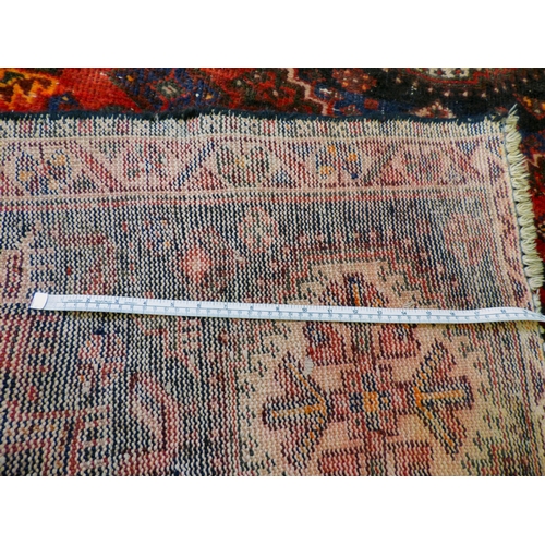 86 - A Persian rug, decorated with repeating stylised designs, on a multi-coloured ground&nbsp; 62