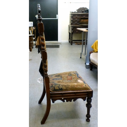 97 - A late Victorian mahogany framed tapestry upholstered nursing chair with carved decoration and barle... 