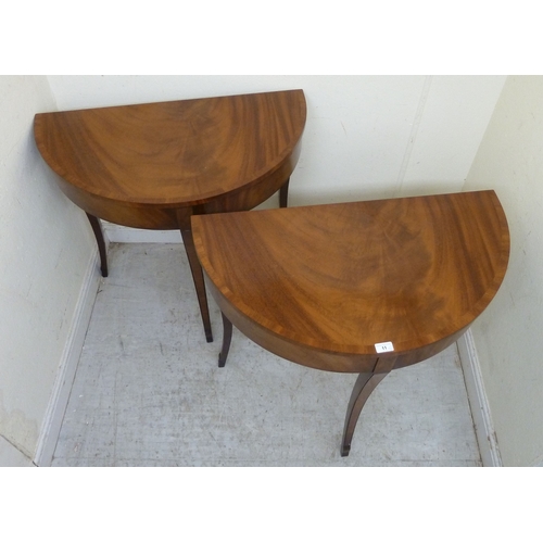 11 - A pair of modern Regency style mahogany finished demi-lune side tables, raised on sabre legs&nbsp; 3... 