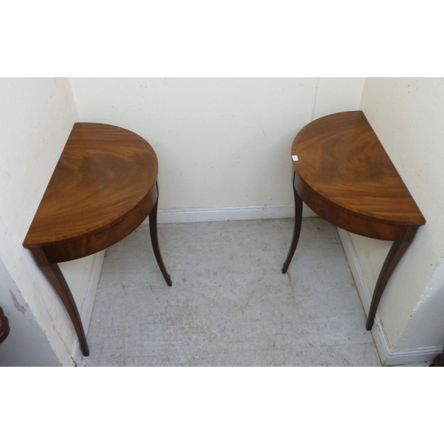 11 - A pair of modern Regency style mahogany finished demi-lune side tables, raised on sabre legs&nbsp; 3... 