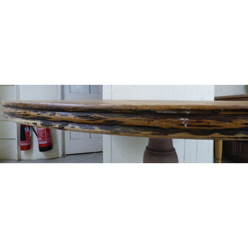 23 - A late 19th/early 20thC bleached mahogany centre table, the top raised on a grey painted pedestal an... 