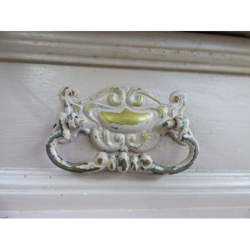 24 - An early 20thC pink painted pine chiffonier with a frieze drawer, over a pair of floral carved panel... 