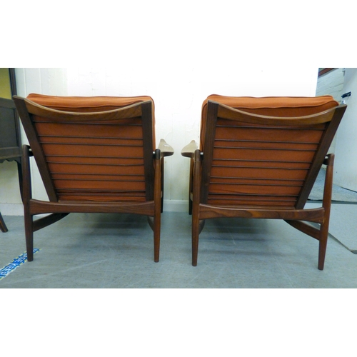 1 - A pair of IB Kofod-Larsen for G-Plan teak framed armchairs, the loose cushions upholstered in orange... 