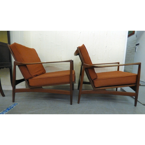 1 - A pair of IB Kofod-Larsen for G-Plan teak framed armchairs, the loose cushions upholstered in orange... 