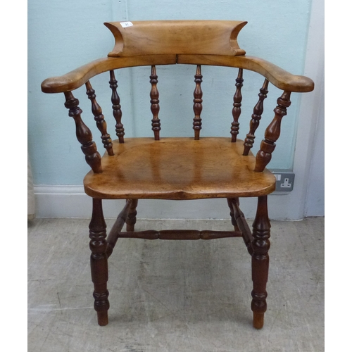 21 - An early 20thC oak Windsor chair with turned supports, raised on turned legs