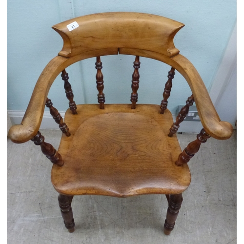 21 - An early 20thC oak Windsor chair with turned supports, raised on turned legs