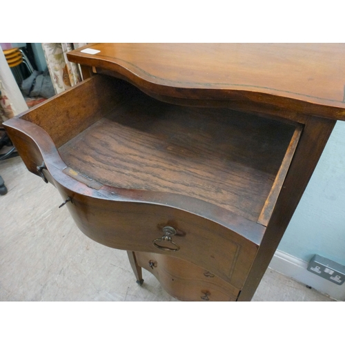 22 - An early 20thC string inlaid mahogany serpentine front chest of drawers, raised on tapered legs and ... 