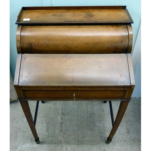 24 - An early 20thC string inlaid walnut finished roll top writing desk with a part-fitted interior, rais... 